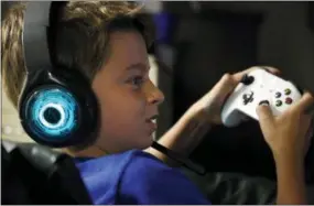  ?? AP PHOTO/MARTHA IRVINE ?? Henry Hailey, 10, plays the online game Fortnite in the early morning hours in the basement of his Chicago home. His parents are on a quest to limit screen time for him and his brother. The boys say they understand sometimes, but also complain that they get less screen time than their friends.