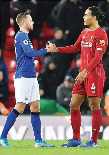  ?? PAUL ELLIS/AFP ?? NAIK LEVEL: Kapten Liverpool Virgil van Dijk bersalaman dengan kapten Everton Gylfi Sigurdsson seusai pertanding­an Premier League di Anfield pada 5 Desember tahun lalu. Liverpool dan Everton sama-sama mendapat suntikan dana dari apparel baru musim depan.