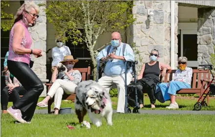  ?? DANA JENSEN/THE DAY ?? Residents of StoneRidge, a senior living community in Mystic, watch Carrie Neri, of Salem, dance with Lyric, a 10-year-old Australian shepherd, while they and their fellow Top Hat and Tails club members perform on May 16.