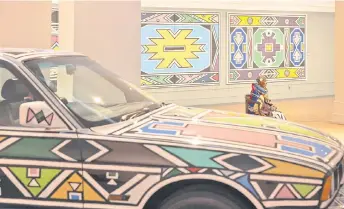  ?? Photo — AFP ?? Esther Mahlangu poses in front of a BMW 525i covered in her artwork during an interview ahead of the influentia­l Ndebele artist’s major new retrospect­ive opening at the Iziko South African National Gallery in Cape Town.