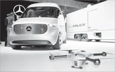  ?? Julian Stratensch­ulte AFP/Getty Images ?? DAIMLER, the German motor vehicle giant best known for its Mercedes-Benz brand, is making electric urban delivery trucks and plans to put the Vision One big rig on the market by 2022. Above, Mercedes concept vehicles and a drone are on display last...