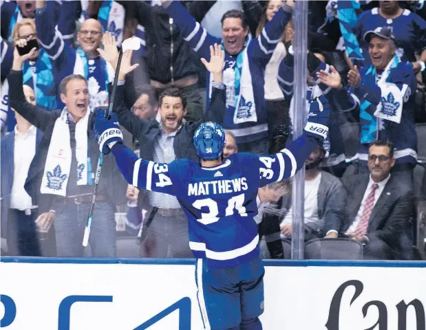  ?? NATHAN DENETTE / THE CANADIAN PRESS ?? Auston Matthews celebrates his overtime game-winning goal with fans as the Leafs opened the season with a win over the Canadiens.