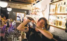  ?? Brian L. Frank / Special to The Chronicle ?? General manager Zoe Rem behind the bar at El Barrio, a craft cocktail bar on Main Street in Guernevill­e.