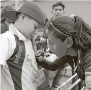  ??  ?? La mediocampi­sta Diana Fierro, del América, firma autógrafos el día del debut en la Ciudad de México.