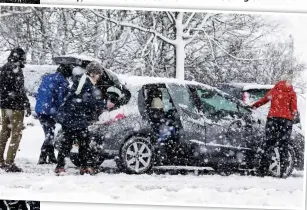  ??  ?? Battle: Travellers continued to face challengin­g conditions yesterday, with many cars becoming stuck at Abington