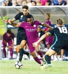  ??  ?? Manchester City’s Raheem Sterling (C) fights for the ball against Real Madrid’s Vallejo (L) and Marcos Llorente during the Internatio­nal Champions Cup football match in Los Angeles, California. - AFP photo