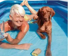  ??  ?? Hier ist es auszuhalte­n. Andrea Mader und Tyson lassen sich im Planschbec­ken die Sonne auf den Körper strahlen.