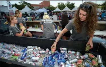  ?? NWA Democrat-Gazette/ANDY SHUPE ?? Chelsea Arenado of Bentonvill­e reaches into an ice-filled container of drinks Wednesday while serving people in the main beer garden near the performanc­e stage in the Walton Arts Center parking lot during the annual Bikes, Blues & BBQ motorcycle rally...