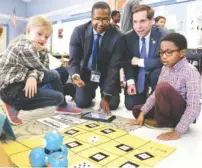  ??  ?? Principal Greg Bagby, second from left, and Fleischman­n work a robot with students Sasha Ponders, left, and Rico Toney Friday.