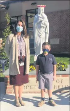  ?? BARBARA ORMSBY - MEDIANEWS GROUP ?? Second-grade teacher Sarah Walkowiak and one of her students, Brayden Moll, 8, stand near the entrance of the recently reopened Our Lady of Angels School in Ridley Township.