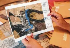  ?? Christophe­r Lee / New York Times ?? Aleida Flores Garcia shows an aerial image of a proposed border wall in July that would cross her property in the tiny Texas village of Los Ebanos.