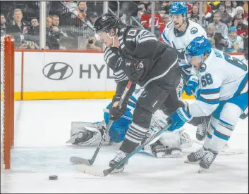  ?? Bebeto Matthews The Associated Press ?? Sharks right wing Mike Hoffman, right, thwarts a second-period scoring chance by Devils left wing Alexander Holtz in San Jose’s 6-3 win Friday at Prudential Center.