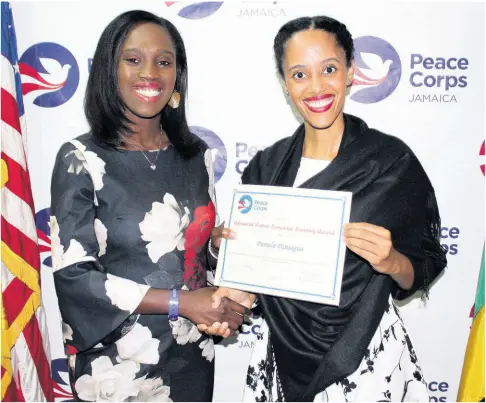  ??  ?? Aisha Harris-Parker on left is Peace Corps of Jamaica Language and Cross Cultural Coordinato­r, she is with Pamela Paniagua, who is receiving an award for scoring high on Patois language assessment.