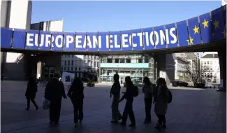  ?? ?? A group stands under an election banner outside the European Parliament in Brussels on April 29, 2024.