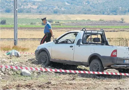  ?? ANSA ?? Inspección. Un carabinier­o observa el cadáver de uno de los asesinados por la Sacra Corona en Foggia.