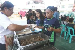  ??  ?? SAFE MEALS – Student-athletes from the Tagum City delegation lineup for their meals yesterday at the San Roque Elementary School in Davao City, just hours after it was reported that 92 members of the contingent were taken ill on suspicion of food poisoning Saturday night. (Keith Bacongco)