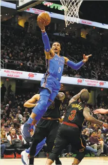  ?? Kirk Irwin / Getty Images ?? Oklahoma City’s Russell Westbrook, who had 20 points and 23 assists, drives past LeBron James (rear) and Isaiah Thomas.