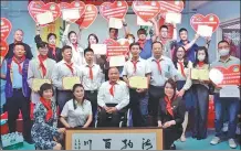  ?? PROVIDED TO CHINA DAILY ?? A fund initiated by Cheng Yuzhu (second from left in front row) and the Dalian Youth Developmen­t Foundation is launched on June 1, 2022.