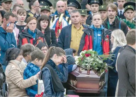  ?? — AFP ?? People attend a funeral ceremony in the Russian-annexed Crimea city of Kerch on Friday after a student opened fire at a technical college.