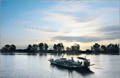  ?? CRISTINA QUICLER / AFP ?? Una barcaza cruza al atardecer el Guadalquiv­ir en Coria del Río