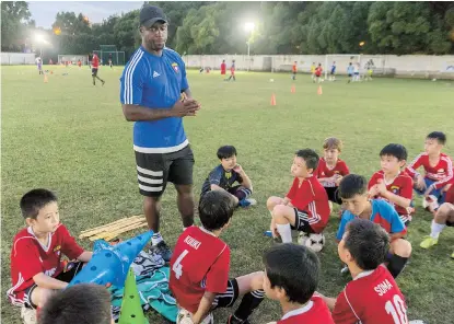  ??  ?? Isaac Asare encourages his young players. — Zhou Shengjie