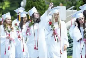  ?? ARNOLD GOLD — NEW HAVEN REGISTER ?? Sacred Heart Academy graduates Katie Mackey (center) assists Anna Claire with her tassel while processing into commenceme­nt exercises outside of the Philip Paolella, Jr. Recreation­al Center at the school in Hamden on Saturday.