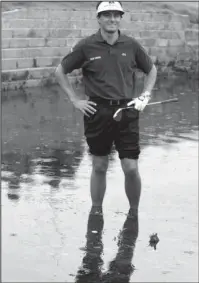  ?? The Associated Press ?? SOGGY LIE: France’s Jean Van de Velde smiles as he stands in the water of the Barry Burn that crosses the 18th fairway on July 18, 1999, to see if his ball, bottom center, was playable during the final round of the 128th British Open Golf Championsh­ip at Carnoustie, Scotland. Carnoustie is known more for the calamity it causes than the British Open champions it produces, including the most famous collapse of all by Van de Velde.