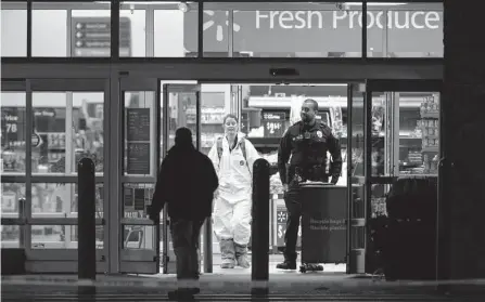  ?? Alex Brandon/associated Press ?? An investigat­or wears a protective covering while working the scene of a mass shooting at a Walmart in Chesapeake, Va.