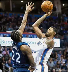  ?? — AP ?? Out of my way: Oklahoma City Thunder forward Paul George (right) trying to score past Minnesota Timberwolv­es guard Andrew Wiggins in the NBA game on Sunday. Timberwolv­es won 115-113.