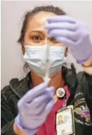  ?? KAMIL KRZACZYNSK­I/AFP VIA GETTY IMAGES ?? Registered nurse Florisa N. Lingad prepares a dose of the Johnson & Johnson COVID-19 vaccine on Friday at the Hilton Chicago O’Hare hotel.