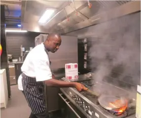  ?? (Reuters) ?? LEON SERAPHIN cooks chicken at the Brigade restaurant in London, which trains and employs homeless people.