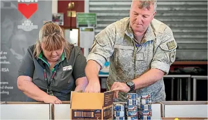  ?? PHOTO: SUPPLIED ?? Grosett and Land Component Commander Brigadier Mike Shapland packing goods.