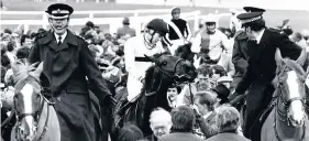  ??  ?? Last Suspect and Hywel Davies, flanked by police officers, on their way back to the winner’s enclosure after the 1985 Grand National at Aintree