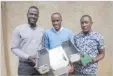  ??  ?? AP PHOTO/STEPHEN WANDERA In this photo taken Monday, June 18, 2018, Ugandan Brian Gitta (L) and team members Moris Atwine, (C) and Shafik Sekito show the non-invasive malaria test that Gitta invented in Kampala, Uganda.