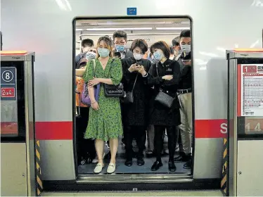  ?? Picture: NOEL CELIS/AFP ?? VIRUS LINGERS: Passengers on a subway train during rush hour in Beijing on Monday