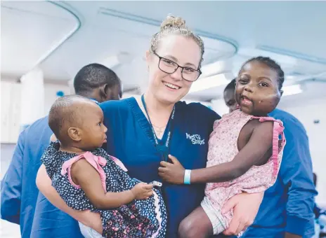  ??  ?? CARE FACTOR: Nurse Jess Davis with young patients on a hospital ship off Cameroon.