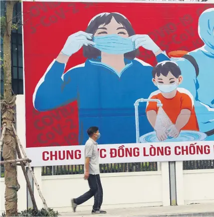  ??  ?? In Hanoi mahnen Plakate zur Einhaltung der Maßnahmen zur Eindämmung der Coronapand­emie.