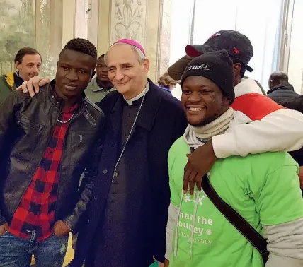  ??  ?? Abbraccio L’arcivescov­o Matteo Zuppi abbraccia due migranti che hanno partecipat­o ieri al pellegrina­ggio mondiale organizzat­o dal 2017 dalla Caritas