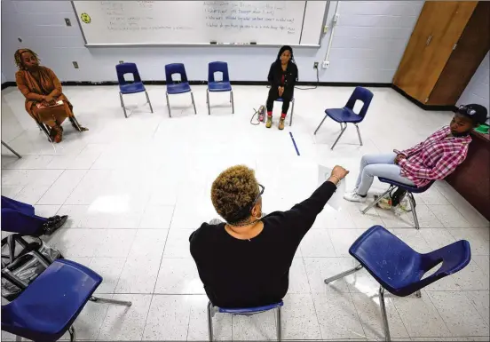  ?? PHOTOS BY BOB ANDRES/ROBERT.ANDRES@AJC.COM ?? Jacqueline Beard-Cathey, school community facilitato­r, helps Tri-Cities High School students with conflict resolution, including lessons on how to become more calm after something has clouded their judgment. They collective­ly came up with ideas of listening to music, talking to someone or writing.