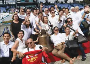  ??  ?? Residents from Balangiga town pose for a photo next to one of the three Balangiga church bells shortly after it arrived from the US at a military airbase in Manila.