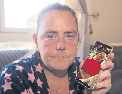  ?? Picture: The Sun/ News Licensing. ?? Sandra with a picture of her husband. She and her stepdaught­er will split the deceased’s ashes.