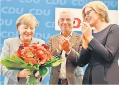  ??  ?? Merkel (left) holds a bouquet of flowers as she is applauded by two of five vice party chairmen of her conservati­ve Christian Democratic Union (CDU) Thomas Strobl (centre) and Julia Kloeckner as they arrive for a meeting with their party’s leadership...