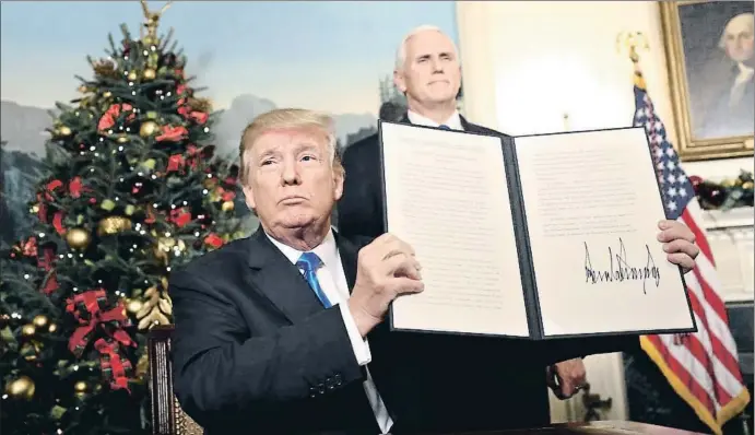  ?? JIM LO SCALZO / EFE ?? El presidente Trump muestra la orden firmada por la que reconoce a Jerusalén como capital de Israel, en la Casa Blanca; detrás, el vicepresid­ente, Mike Pence