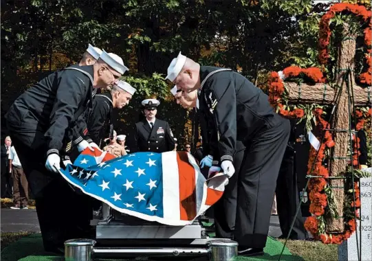  ?? RICHARD MESSINA/FOR THE LOS ANGELES TIMES ?? Pallbearer­s remove the flag from the casket holding the remains of Navy Fireman 3rd Class Edwin Hopkins, who died at Pearl Harbor, at Woodland Cemetery in New Hampshire.