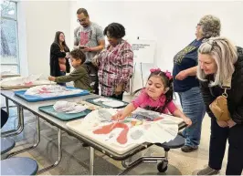  ?? ?? Preschool students from Clark Early Learning Center, their parents and school staff painted to show how one of the new studios will be used during the Springfiel­d Museum of Art’s celebratio­n of its newly renovated north wing on Saturday.