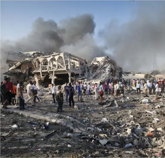  ?? Bild: FARAH ABDI WARSAMEH/TT ?? ATTENTATSP­LATSEN. Överlevand­e och ögonvittne­n inspektera­r förödelsen efter ett av gårdagens bombdåd i Mogadishu.