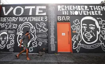  ?? Mario Tama / Getty Images ?? A mural in Los Angeles features images of deceased Black shooting victims Ahmaud Arbery, George Floyd and Breonna Taylor. Arbery was gunned down by two white men in Georgia while jogging.