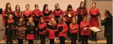  ?? Fotos (2): Carolina Müller ?? Der gemischte Chor des Aichacher Gymnasiums bei seinem Auftritt beim Weih nachtskonz­ert (oben). Die Schüler des Jugendchor­es traten in roten Shirts oder Klei dern auf. Auch stimmlich bewiesen sie Einklang.