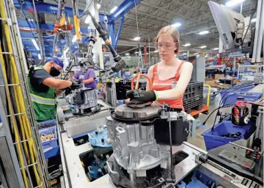  ?? MIKE DE SISTI/MILWAUKEE JOURNAL SENTINEL ?? Generac employee Sherri Wetleitner assembles engines that go into air-cooled home standby generators Tuesday at Generac in Whitewater. Generac has added hundreds of jobs in recent months and is busy making generators needed because of Hurricane Ida.