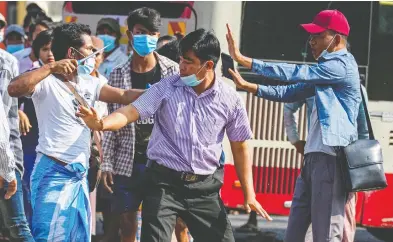  ?? STRINGER / REUTERS ?? A military supporter points a sharp object at pro-democracy protesters at a rally in Yangon, Myanmar, on Thursday.